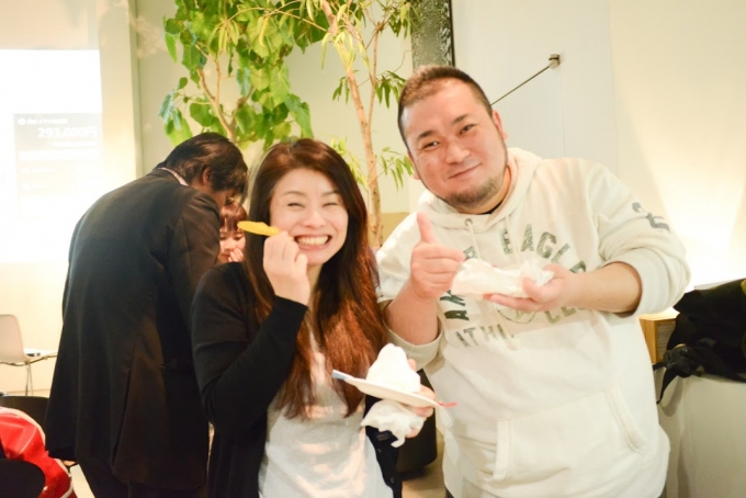 【写真】ケータリングのフードを片手に満面の笑顔で食事と交流を楽しむ参加者の2人。