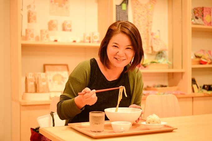 【写真】堺市健康福祉局、障害者支援課のかわせさん。笑みを浮かべながらうどんをすすっている。