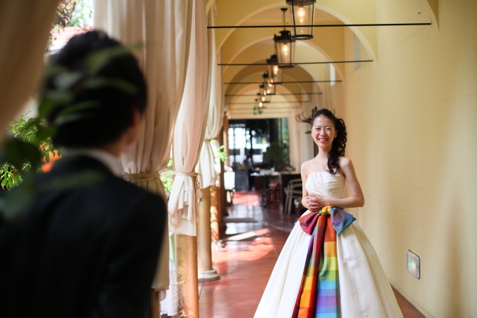 【写真】夫に満面の笑みで微笑みかけるウェディングドレスを着た花嫁