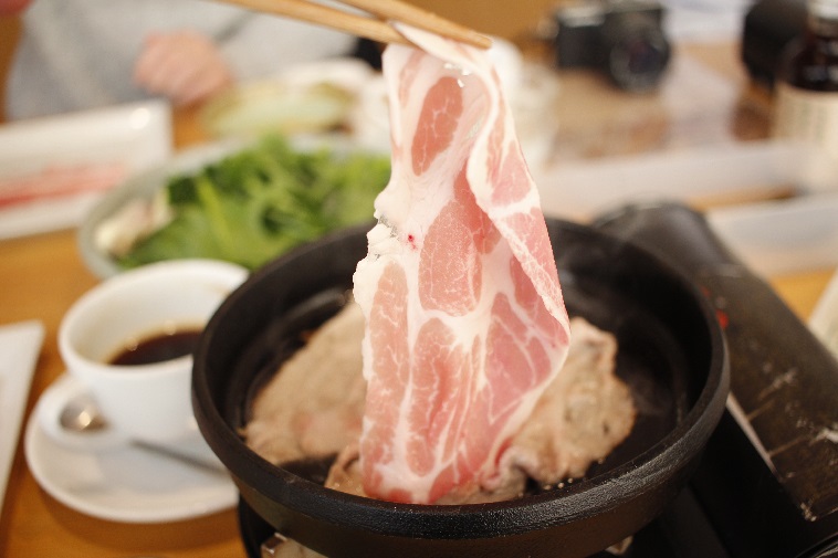 【写真】しゃぶしゃぶの豚肉を鍋に入れる。サシが入って美味しそう