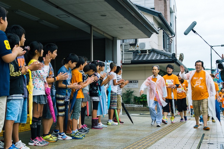 【写真】RUN伴の参加者と、彼らを街頭で応援する子どもたち。温かな空気が流れている。