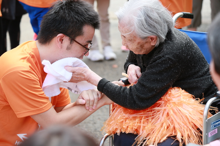 【写真】参加者のおばあさんが、参加者の若者を気遣っている。優しい空気が漂っている。