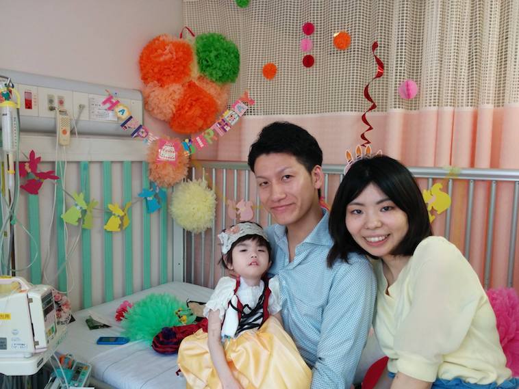【写真】誕生日の飾り付けが施されたベッドの上で撮影された、家族3人の写真