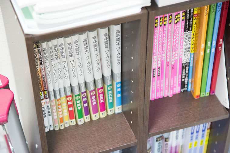 【写真】本棚には高卒認定ワークブックなど学習本が並ぶ