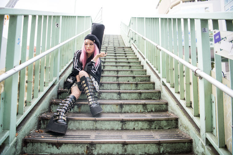 【写真】歩道橋の階段で座りポーズをとるりささん
