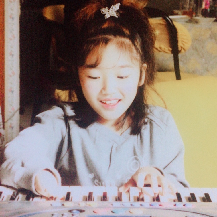 【写真】幼い頃のりささん、ピアノを楽しそうに弾いている。