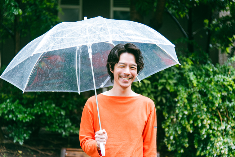【写真】傘をさし、笑顔で立っているみやざきさん