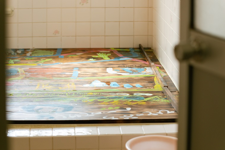 【写真】ぶんじ寮のお風呂のふたは、アーティストによる絵が描かれている