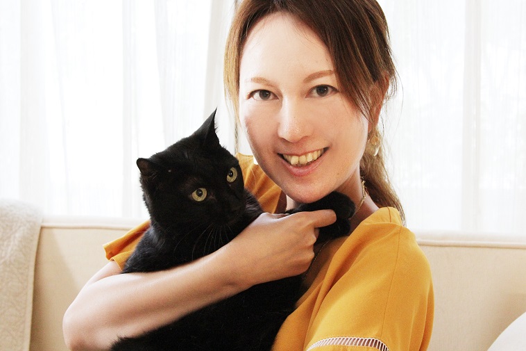 【写真】愛猫のあいを抱え微笑むさきさん