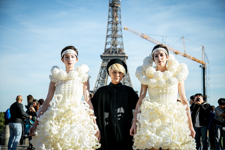 【写真】風船で作られた衣装を着たモデル2人と写る神宮さん。2018年にフランスのパリにて撮影。