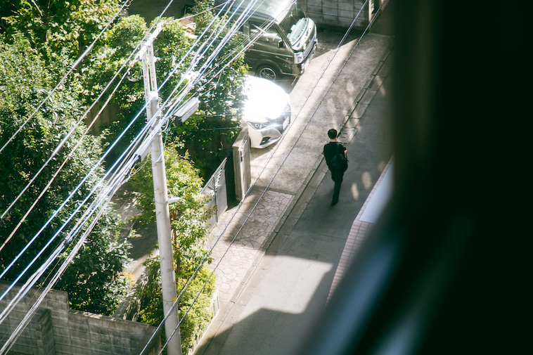 【写真】取材を行った法律事務所の窓から見た景色。一人住宅街を歩いている人がいる。