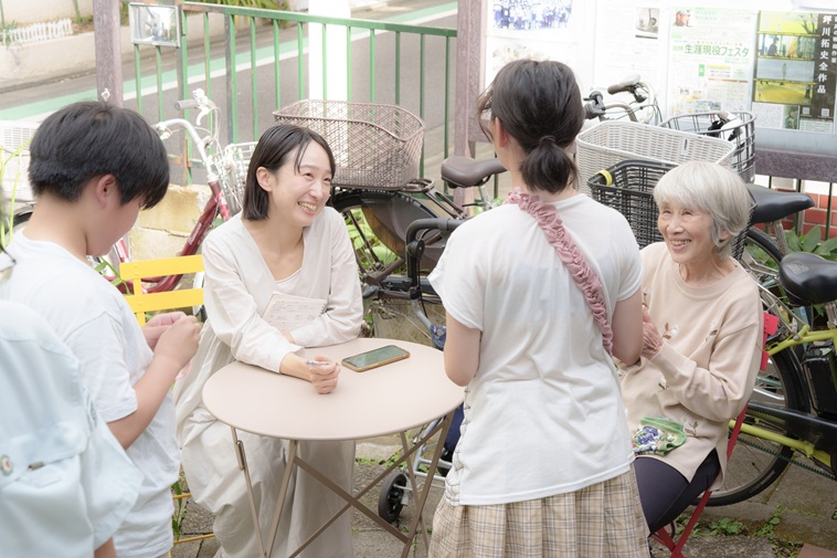 【写真】テーブルを囲んで話す子どもたちと、やのさん、ライターとく