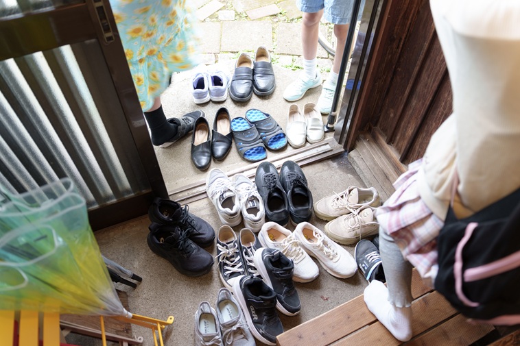 【写真】玄関の外にまでたくさんの靴が並んでいる
