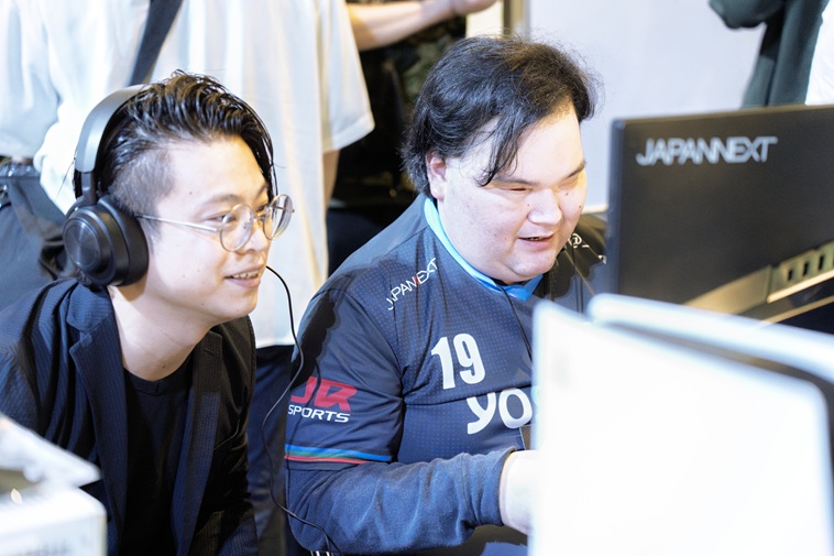 【写真】つるたさんときたむらさんがモニターの前で一緒にゲームをプレイしている様子