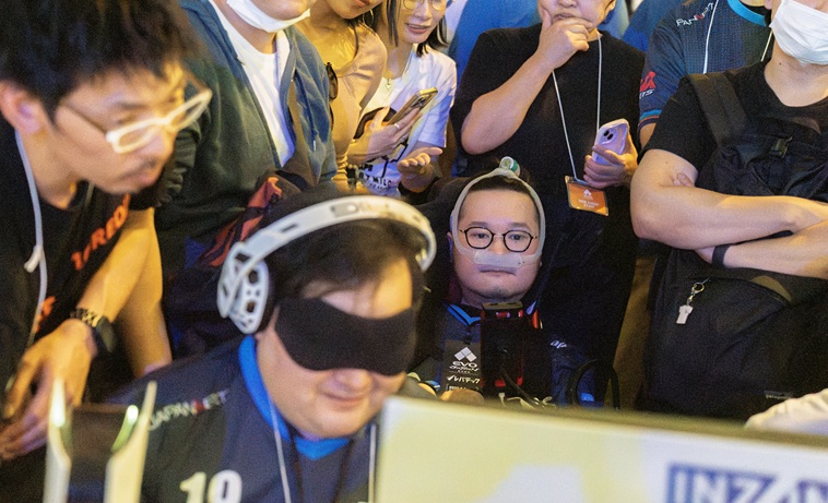 【写真】きたむらさんのプレイ中、後から真剣な表情で見守るはたけやまさん