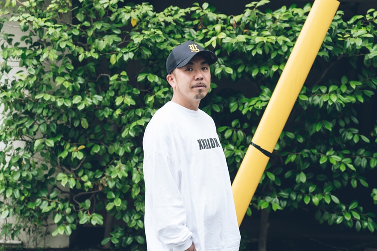 【写真】緑を背景にカメラを見つめるしんぺいたさん