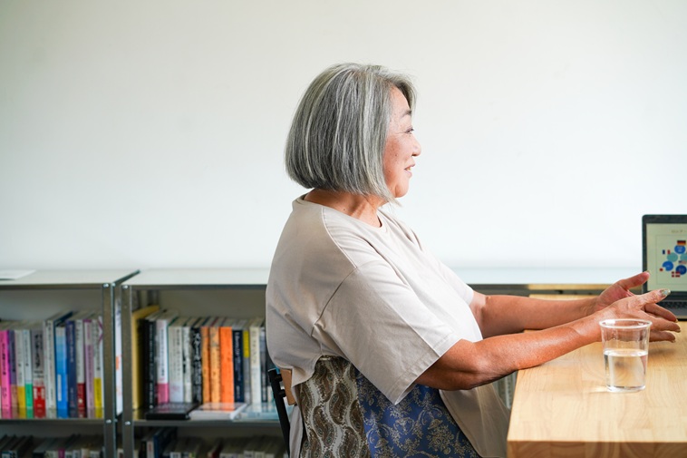 【写真】椅子に座ってお話をするよこやまさん