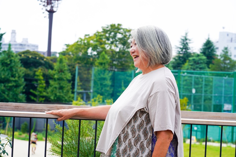 【写真】ベランダにて笑顔を見せるよこやまさんの横顔