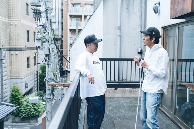 【写真】ベランダで向き合いあって話すしんぺいたさんといしいさん