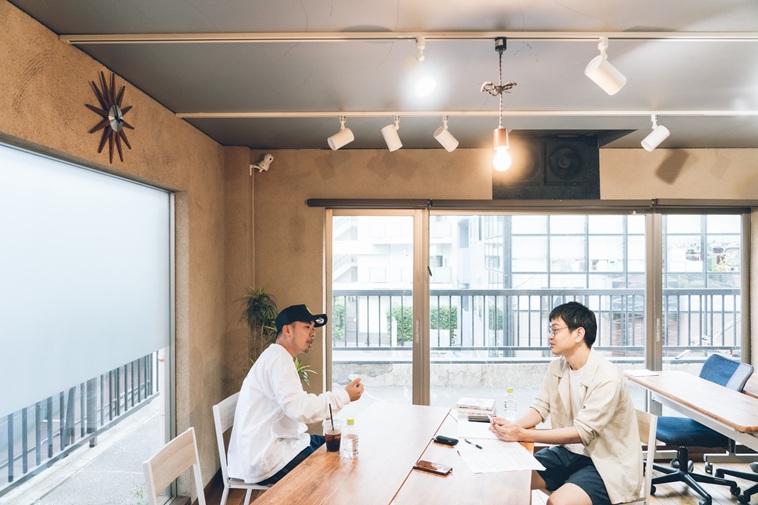 【写真】テーブルをはさんで向かい合って座る、しんぺいたさんとライターのにしやま