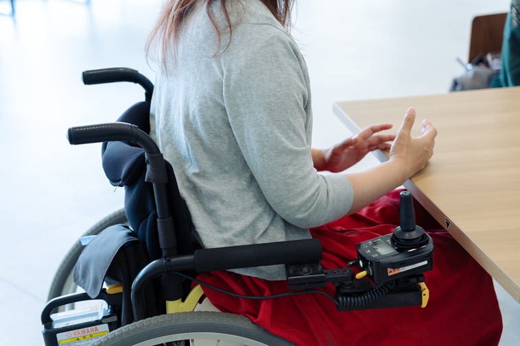 【写真】車いすに座るおざわさんの体