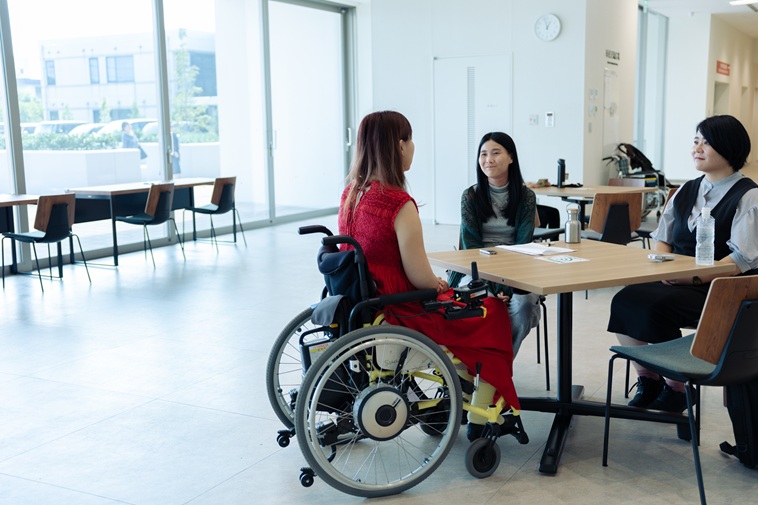 【写真】インタビューを受けるおざわさんと、テーブルを挟んで座るsoarまつもととライターあらた