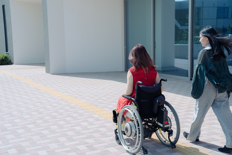 【写真】車いすにのる小澤さんとsoarまつもとが並んで歩く後ろ姿