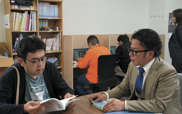 【写真】本を見ながら話すきみづかさんと、話を聞くせおまさたけさん