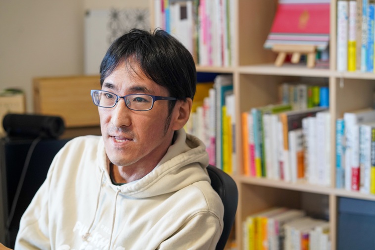 【写真】椅子に座りお話しするかむらさん