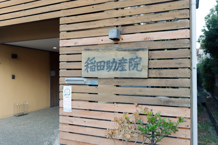 【写真】稲田助産院の入り口。木の温もり感じる外壁に、稲田助産院と書かれた看板が下げられている