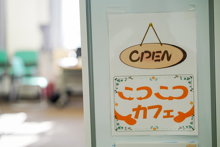 【写真】部屋の入口に、OPENの看板と、「こつこつカフェ」と書かれている