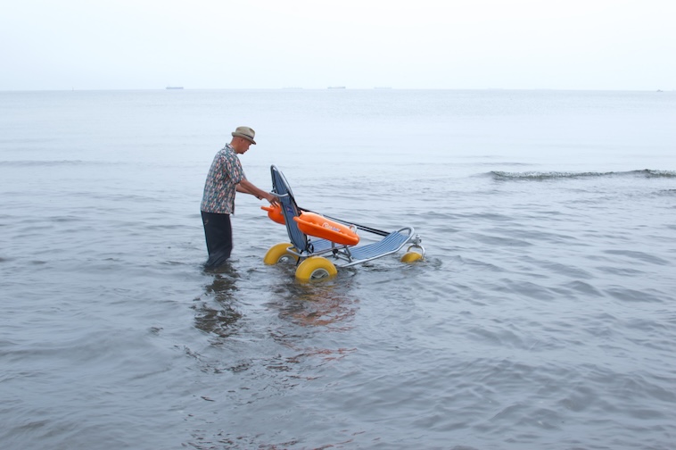【写真】モビチェアを押しながら海に入るにしださん