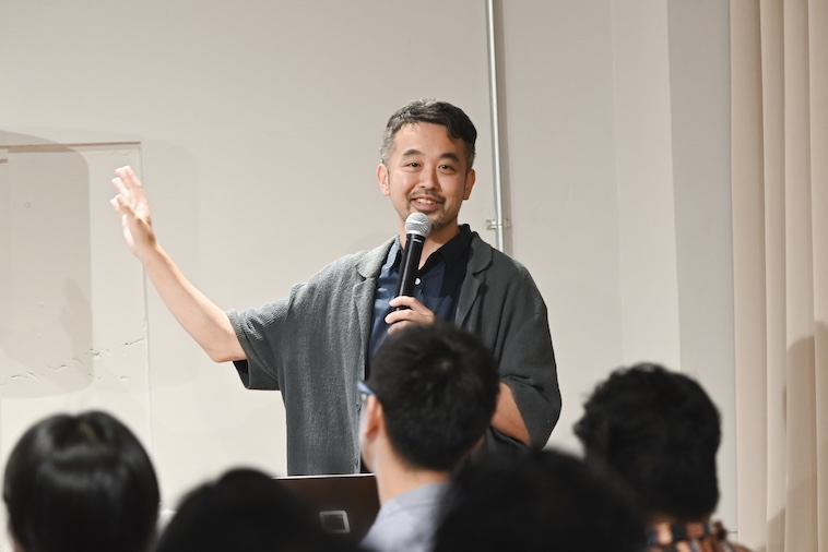 【写真】マイクを持って話すドミニクさん